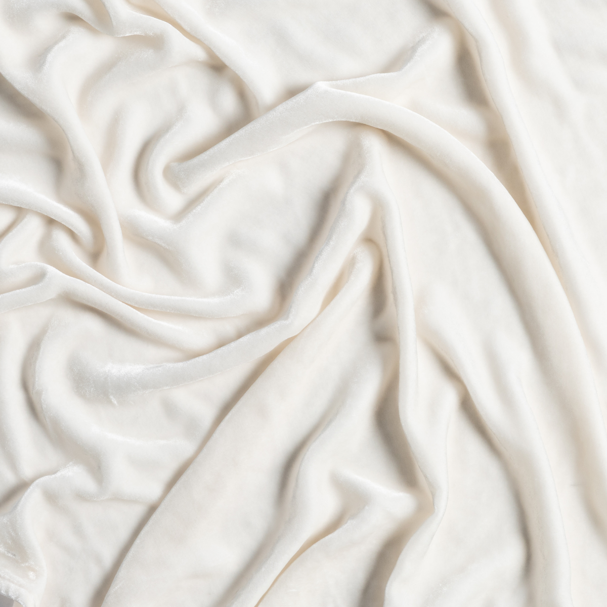 Crema Loulah fabric close-up showing soft draped folds and silky texture.