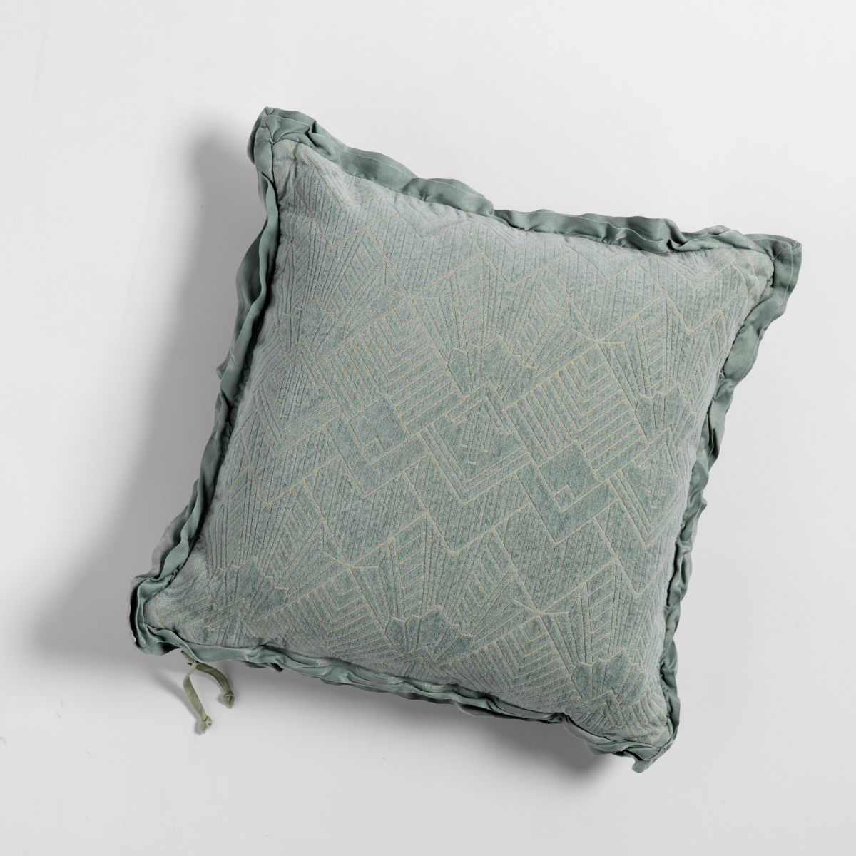 Eucalyptus Trettino throw pillow with geometric jacquard weave and ruffled edge trim.