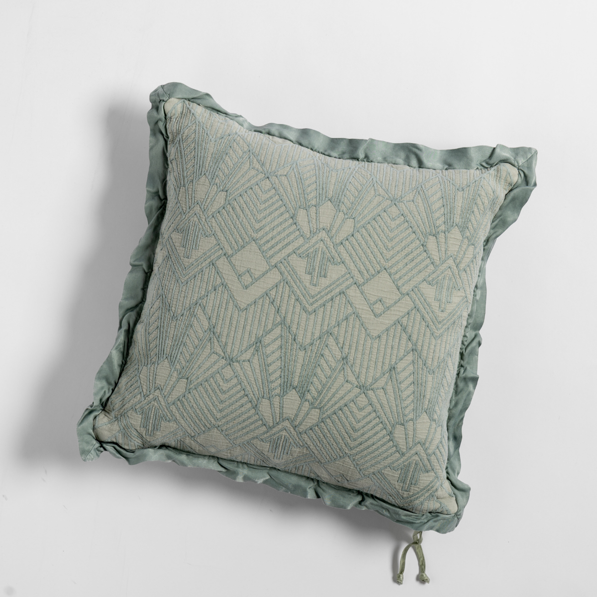 Eucalyptus Trettino throw pillow showing geometric embroidery and ruffled satin edge trim.