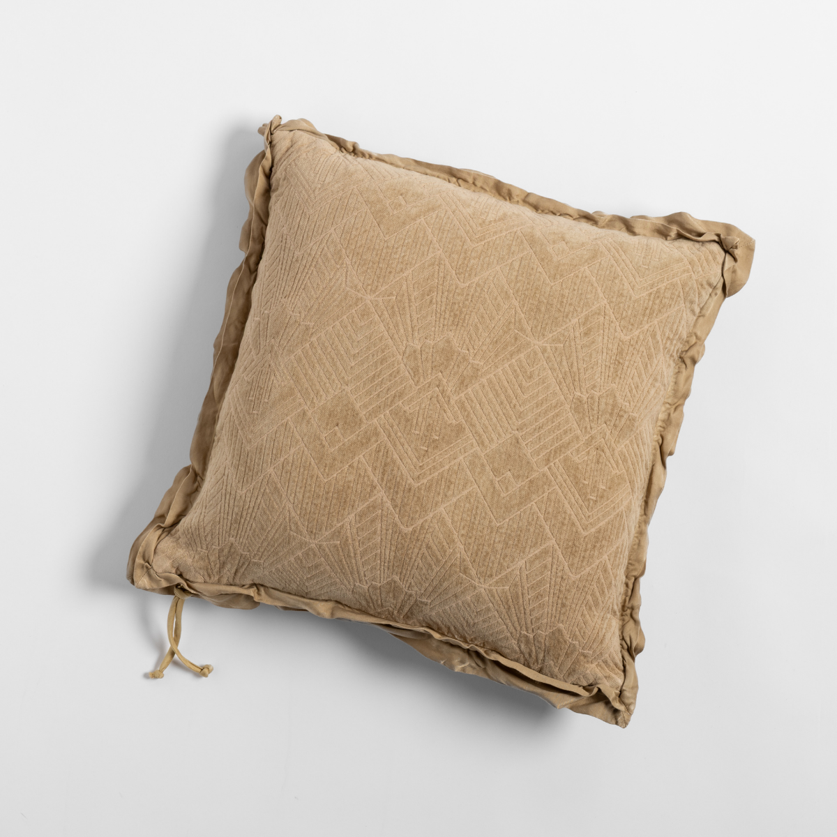Honeycomb jacquard throw pillow with ruffled trim and tie detail, overhead view.