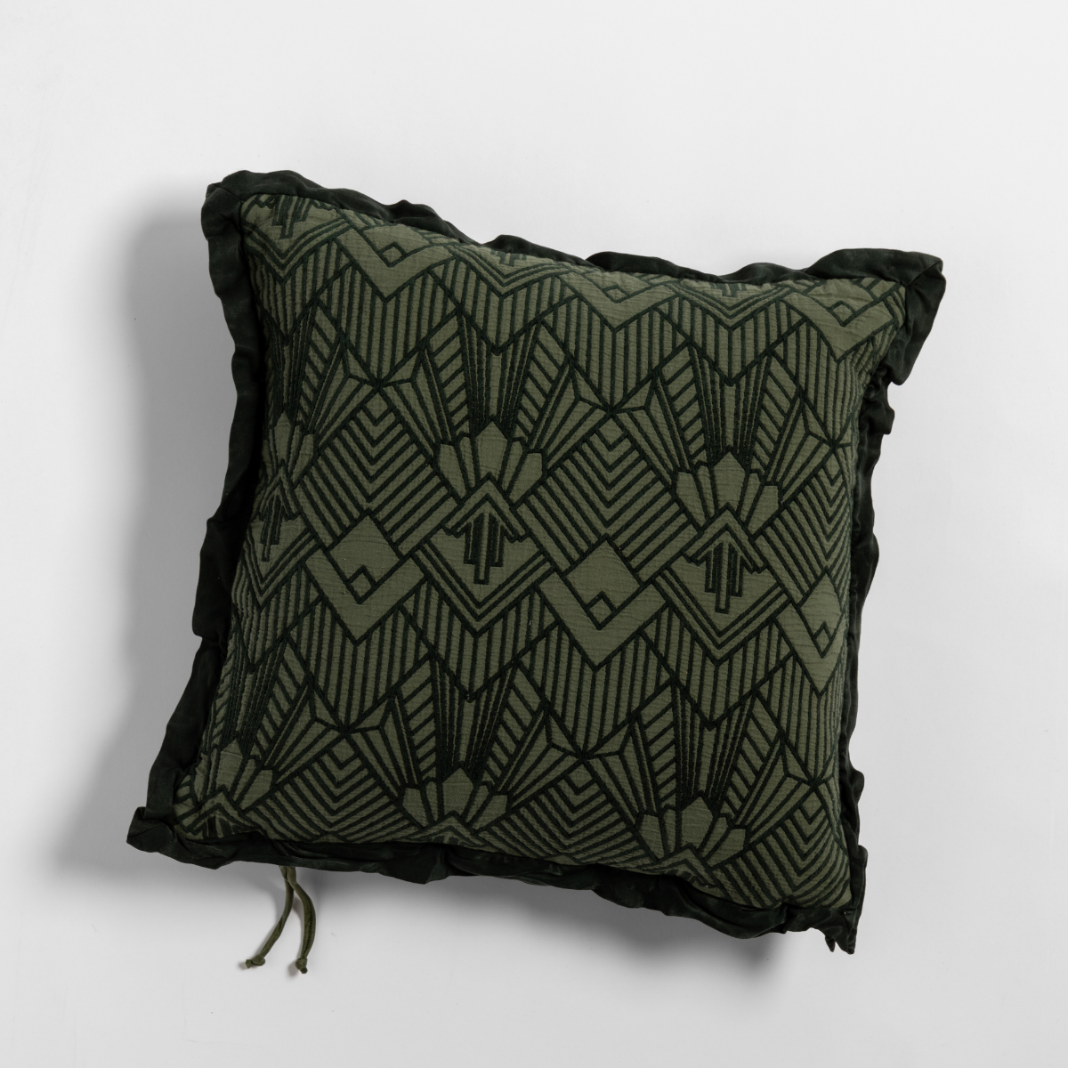 Juniper Trettino throw pillow, close-up showing Art Deco geometric pattern with black fringe trim.