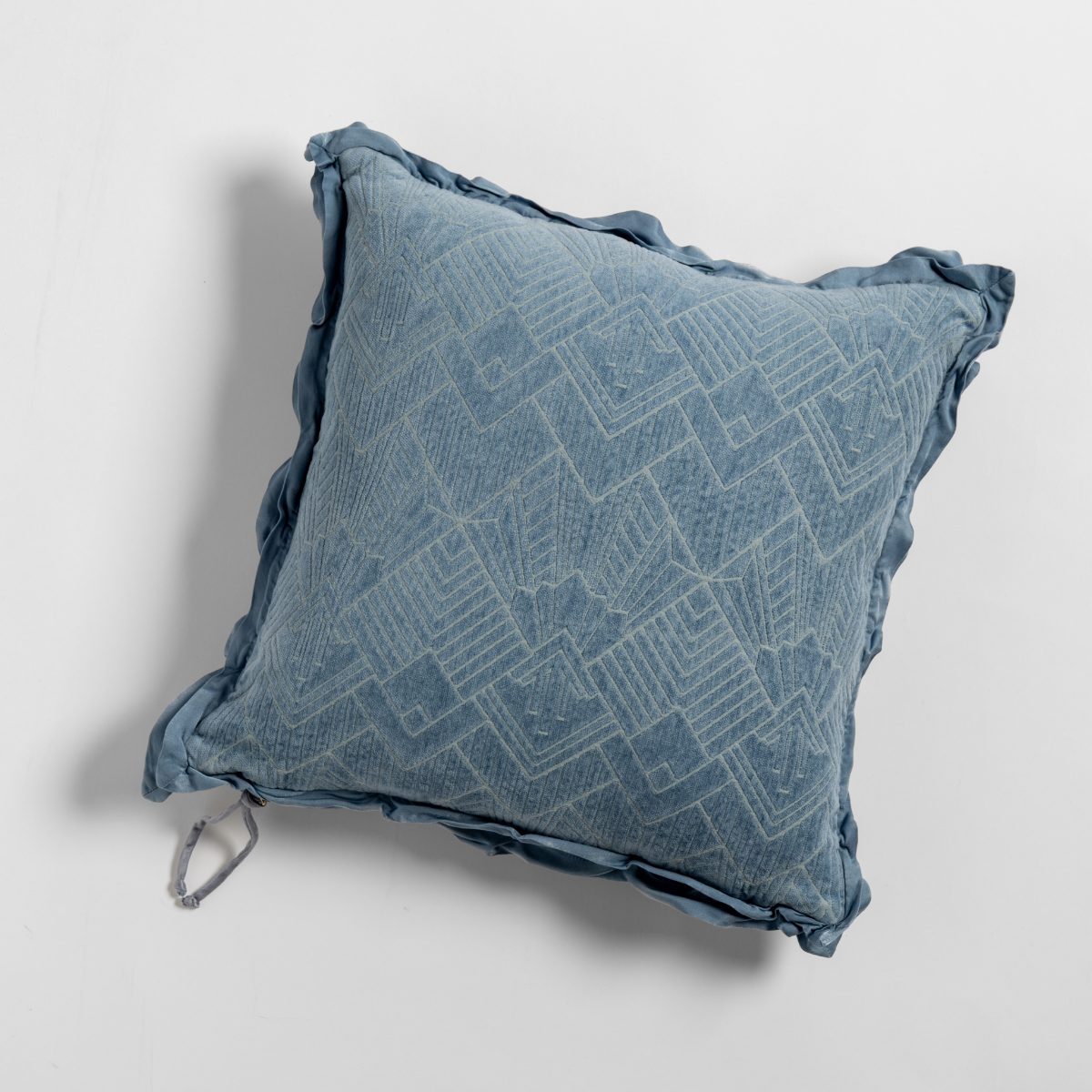 Tahoe Blue throw pillow with geometric jacquard pattern and ruffled edge trim, overhead view.