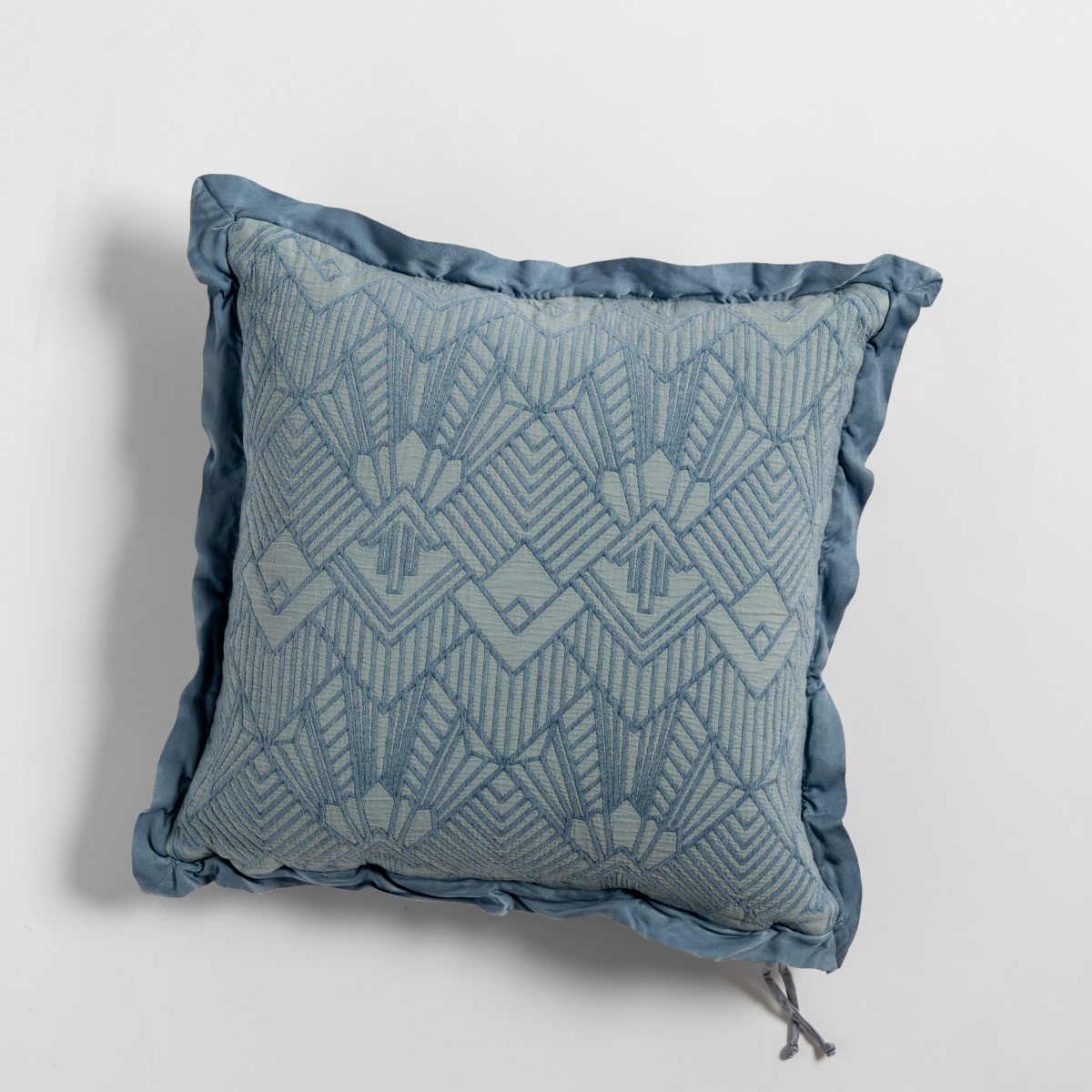 Tahoe Blue throw pillow with geometric jacquard pattern and ruffled satin border detail.