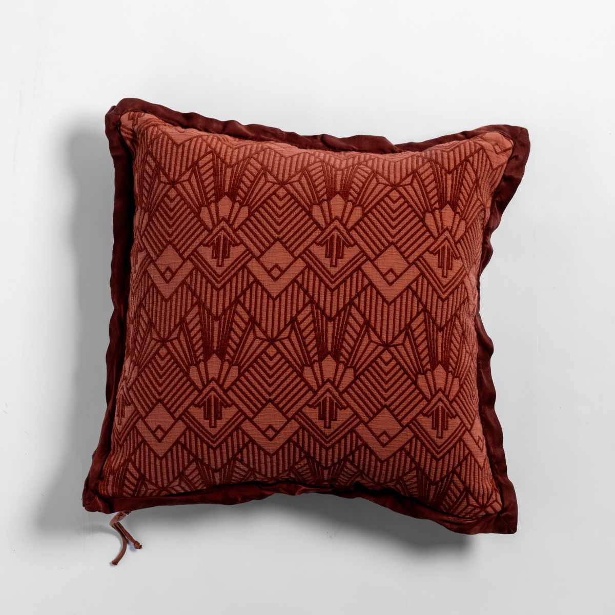 Trettino throw pillow in Autumn, showing geometric Art Deco jacquard pattern with velvet ruffle trim.