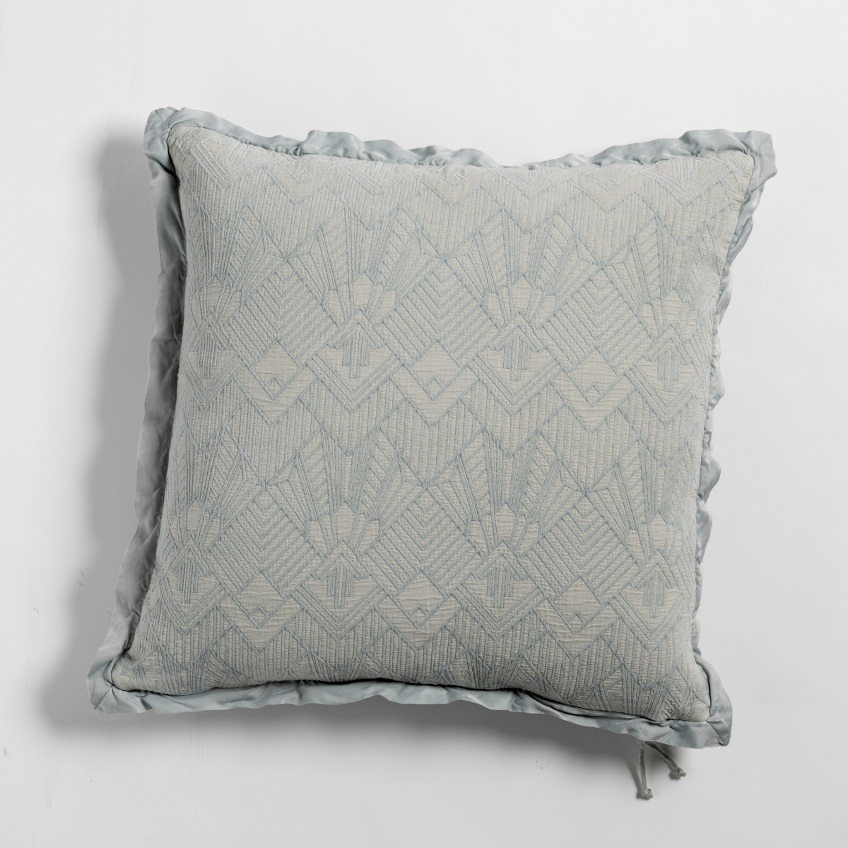 Bella Notte Trettino throw pillow in Cloud with geometric embroidery and ruffled edge trim.