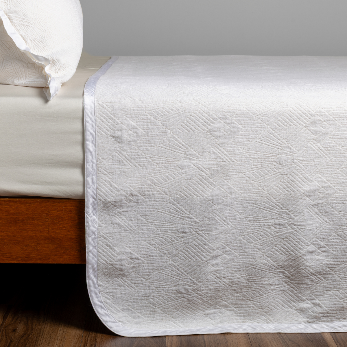 Bella Notte Trettino bedspread in Winter White with quilted texture on a styled bed.