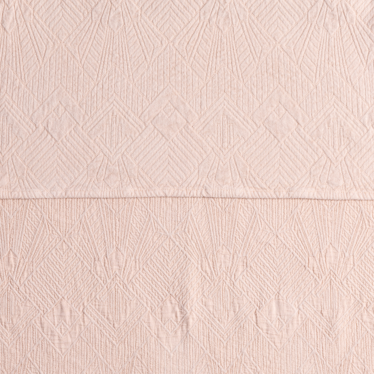 Close-up of Bella Notte Trettino bedspread in Pearl, showing diamond and leaf jacquard weave.