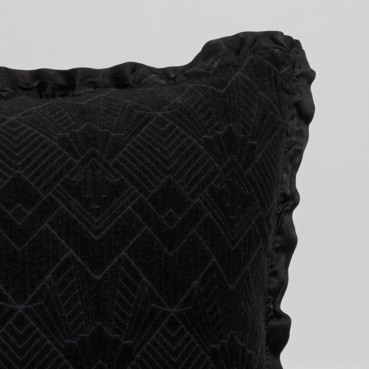 Close-up of Corvino Trettino throw pillow corner showing geometric velvet texture and ruffled trim.