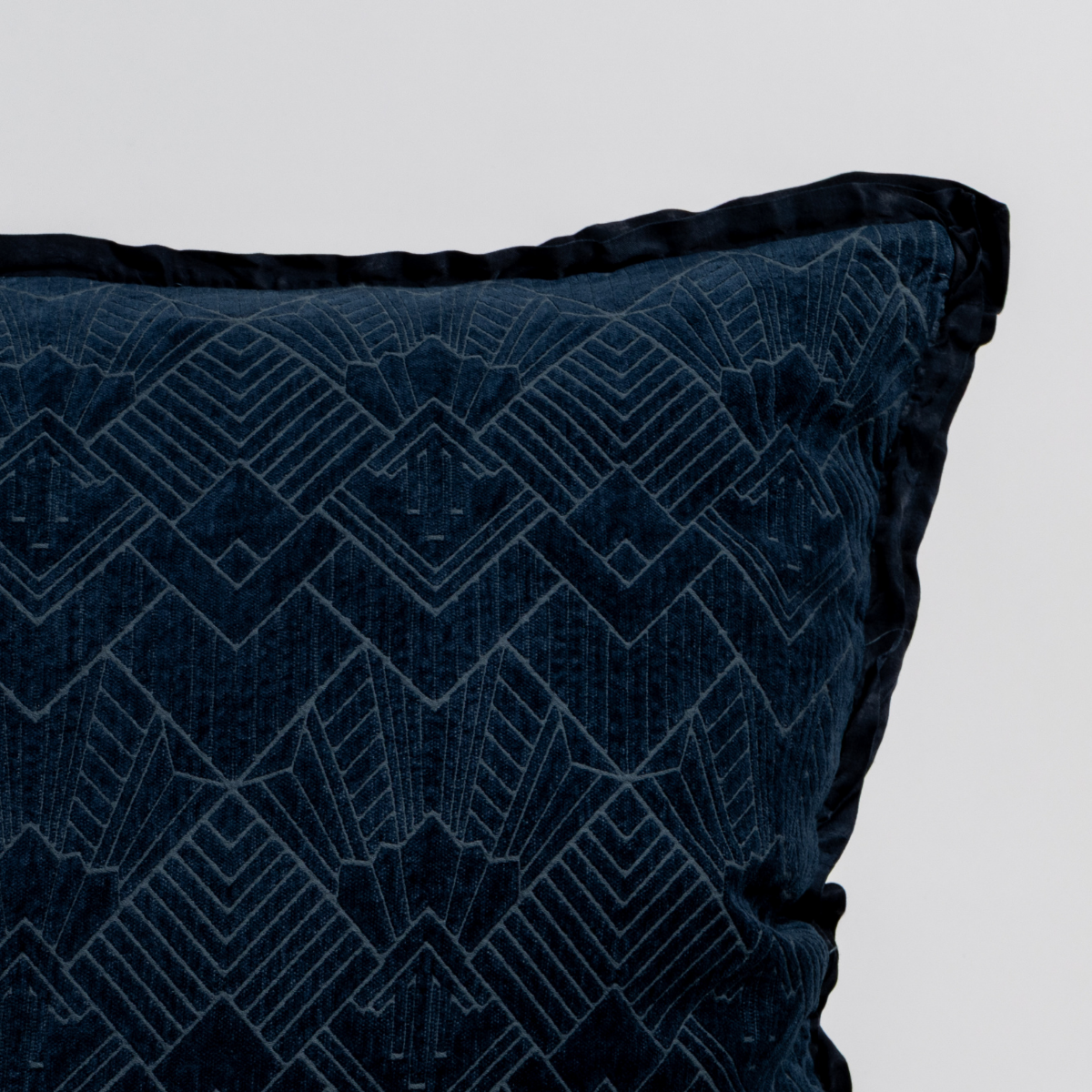 Close-up corner of Bella Notte Trettino throw pillow in Midnight velvet with Art Deco geometric pattern.