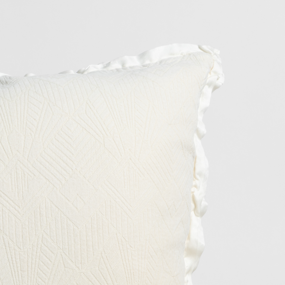 Close-up of Natural Bella Notte Trettino throw pillow corner with ruffled satin trim and textured weave.