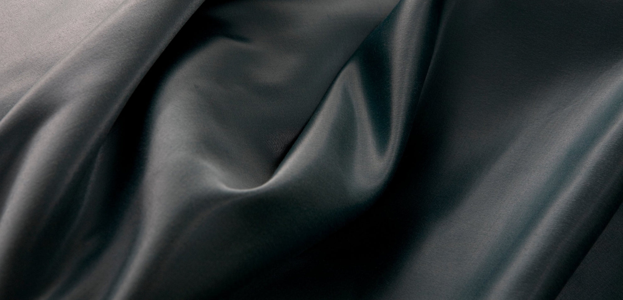 Image of drape details on a blue grey silken fabric.