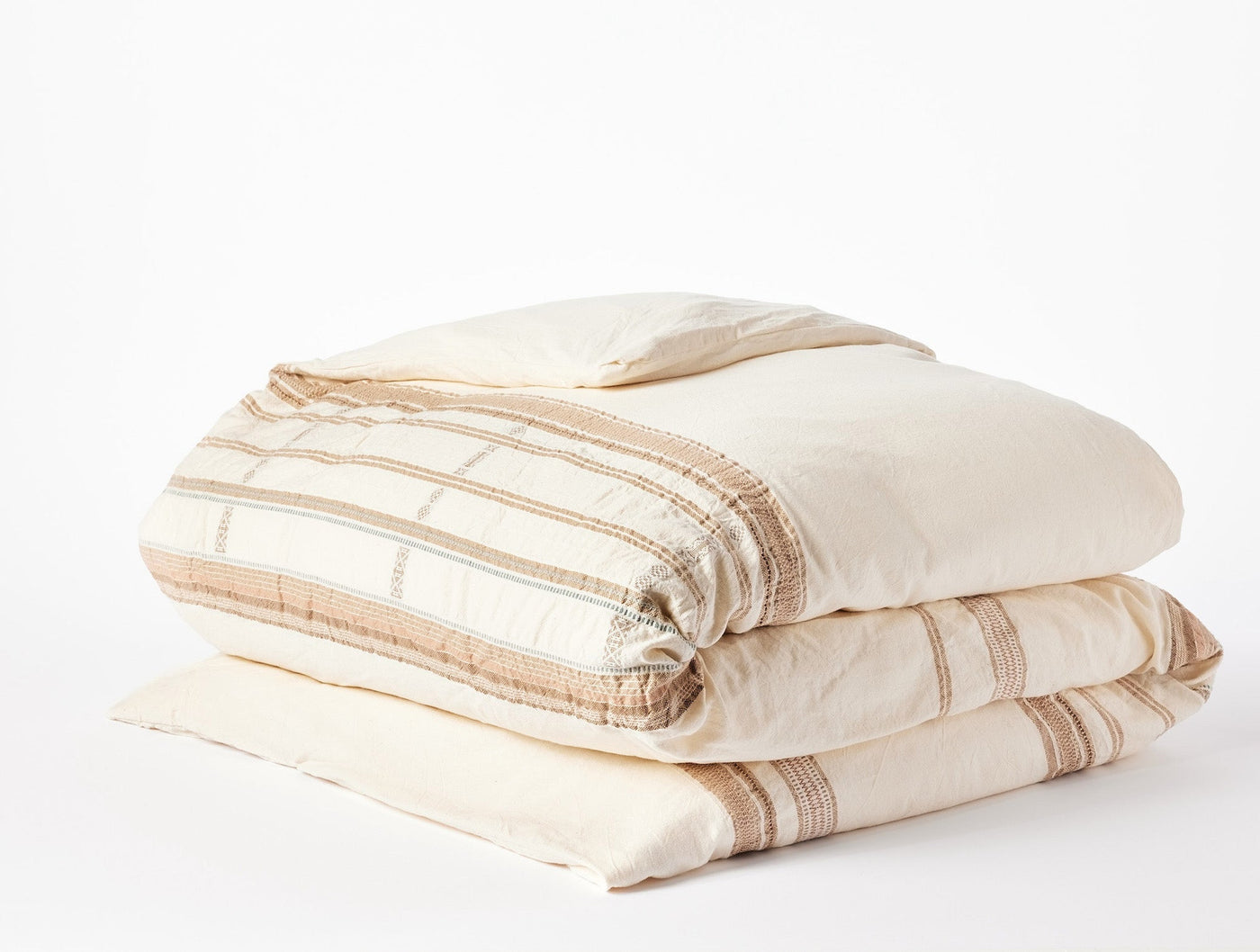 Coyuchi Bodega Bay duvet cover, ivory with tan woven stripe pattern, neatly folded.