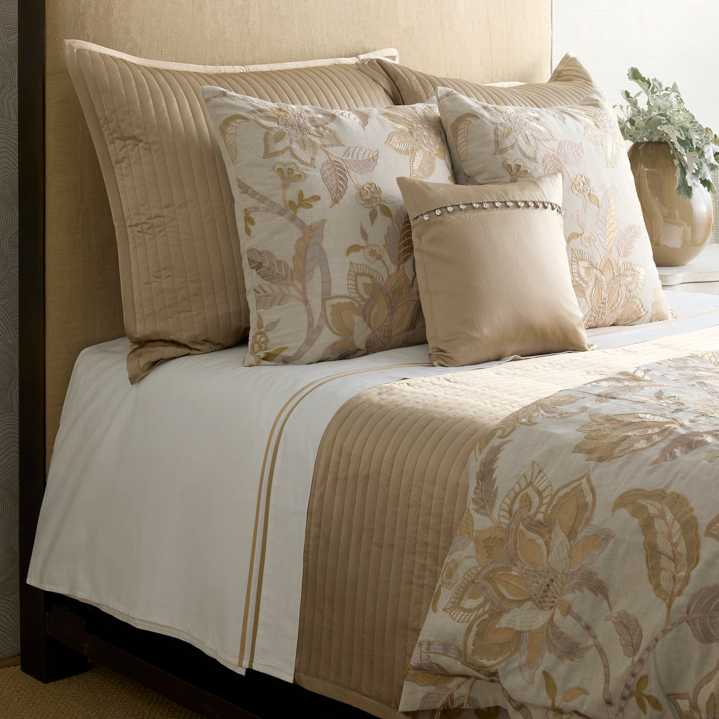 Ann Gish Bramshill duvet cover in champagne, styled with floral and quilted pillows on a made bed.