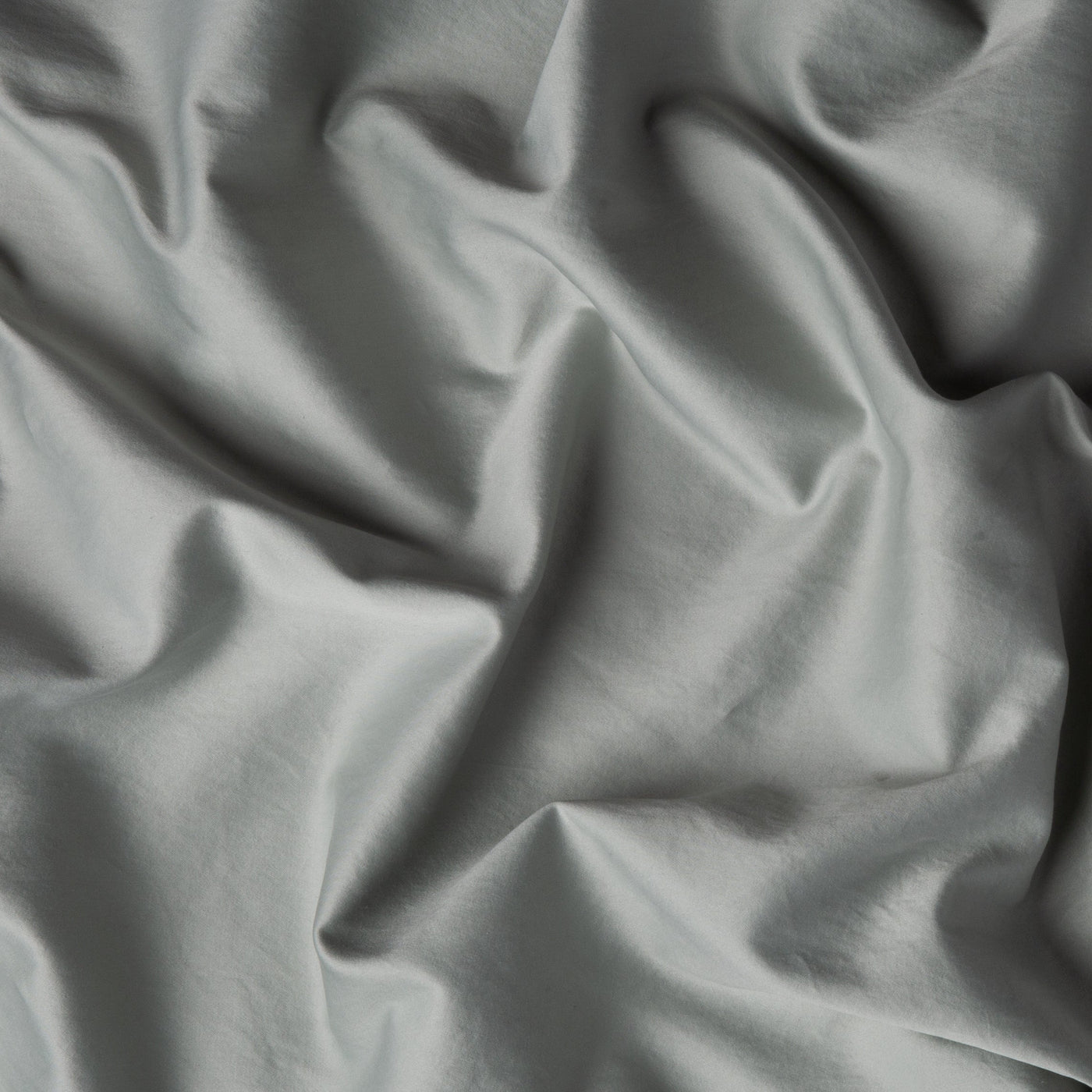 Close-up of Bella Notte Bria duvet cover in Eucalyptus, showing soft draped fabric folds.