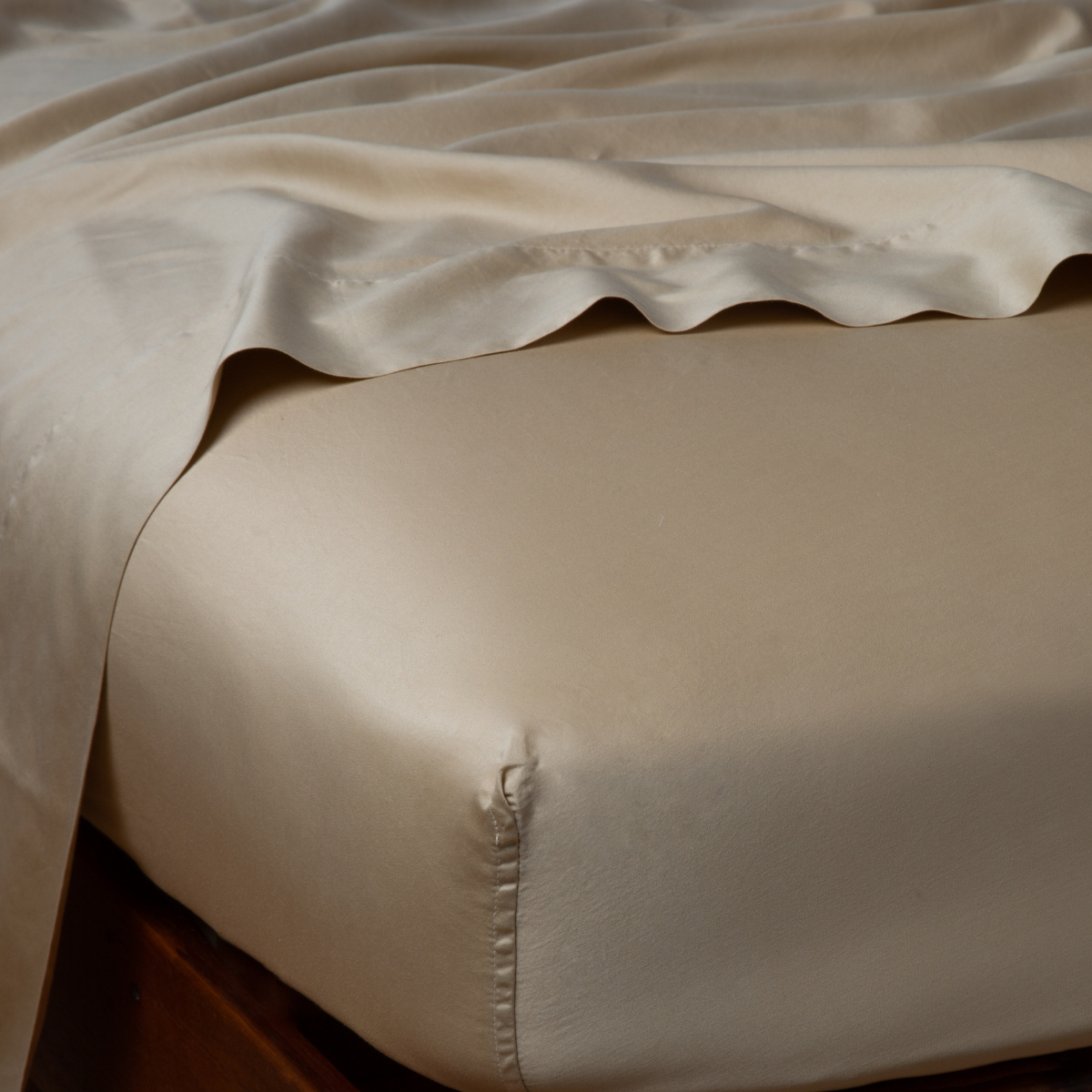 Corner detail of Bella Notte Bria fitted sheet in Honeycomb, showing lustrous silk drape over mattress edge.