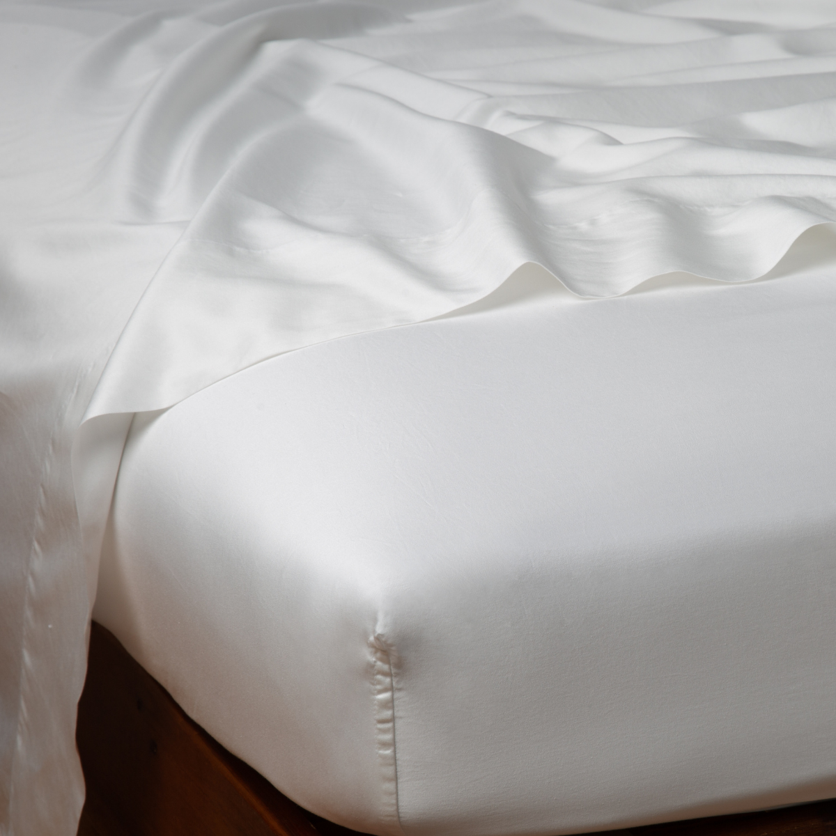 Close-up corner of Bella Notte Bria fitted sheet in Winter White, showing smooth fabric and mattress fit.