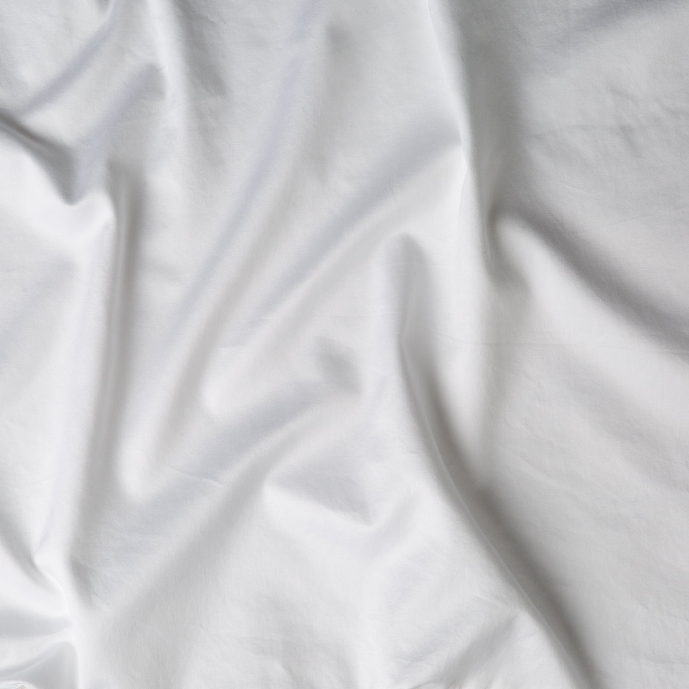 Close-up of White Bella Notte Bria duvet cover fabric with soft, natural draping and folds.