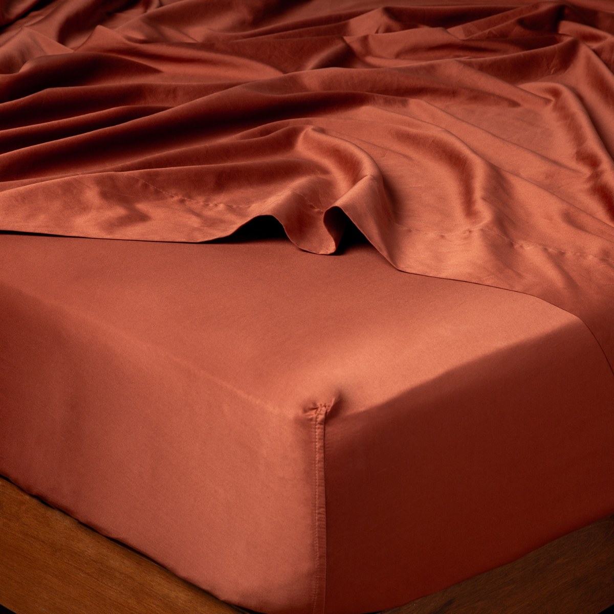 Bria fitted sheet corner detail in Autumn, showing sateen sheen and deep elastic tuck.