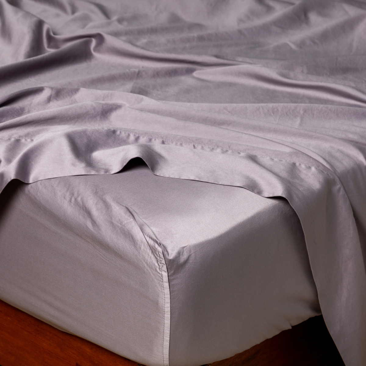 Bella Notte Bria fitted sheet in French Lavender, close-up showing smooth sateen drape on mattress corner.