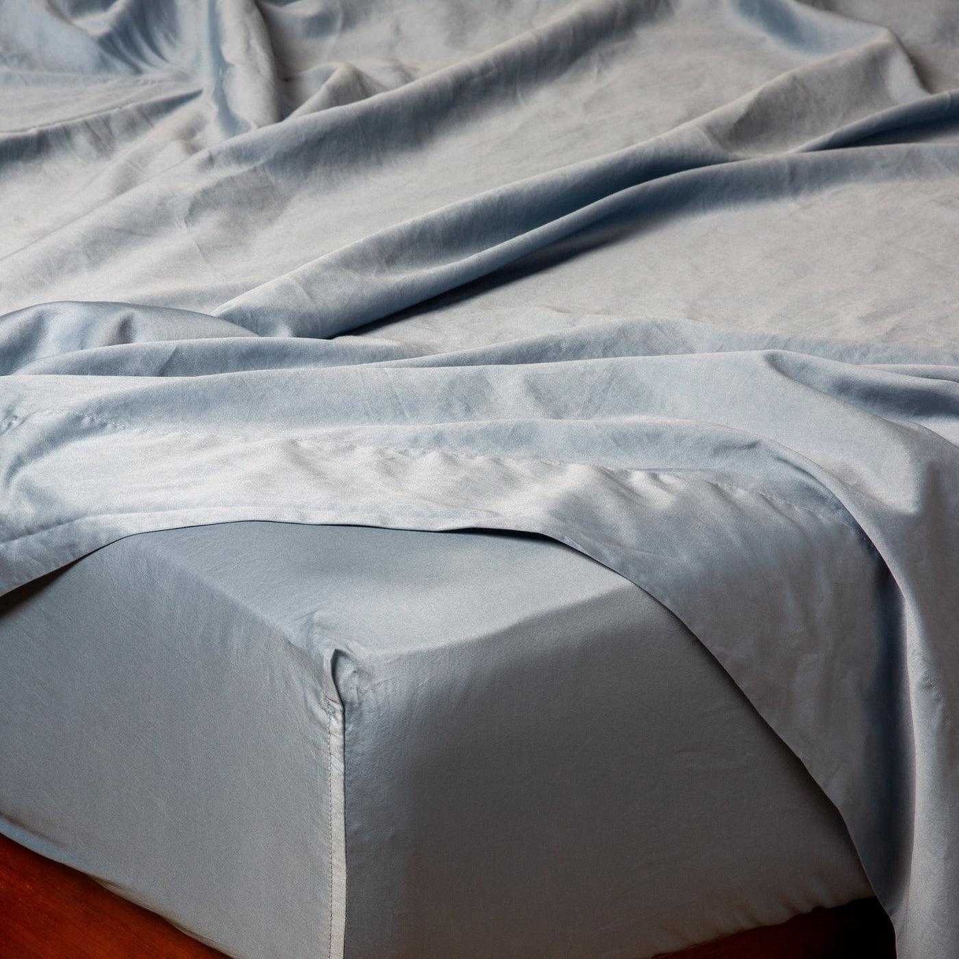 Close-up of Bella Notte Bria fitted sheet in Tahoe Blue, draped loosely over a mattress corner.