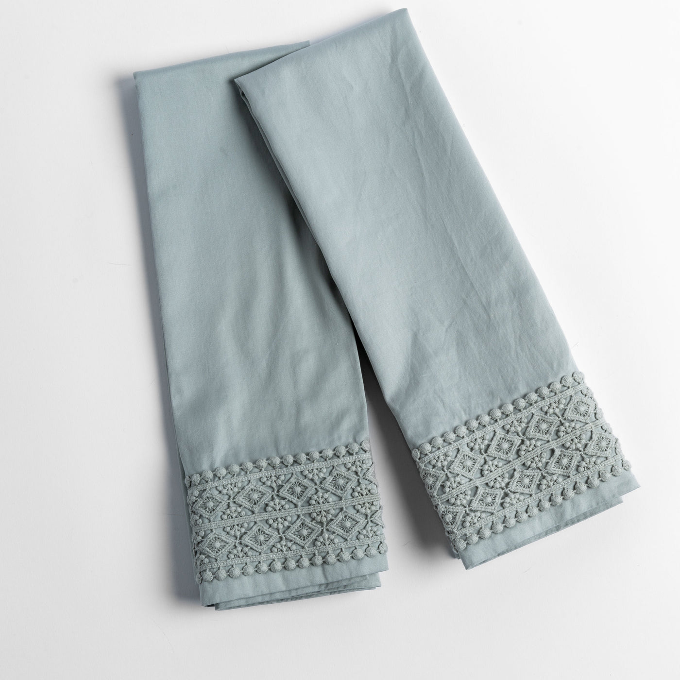 Eucalyptus pillowcase pair showing geometric lace trim detail at cuff, folded flat.