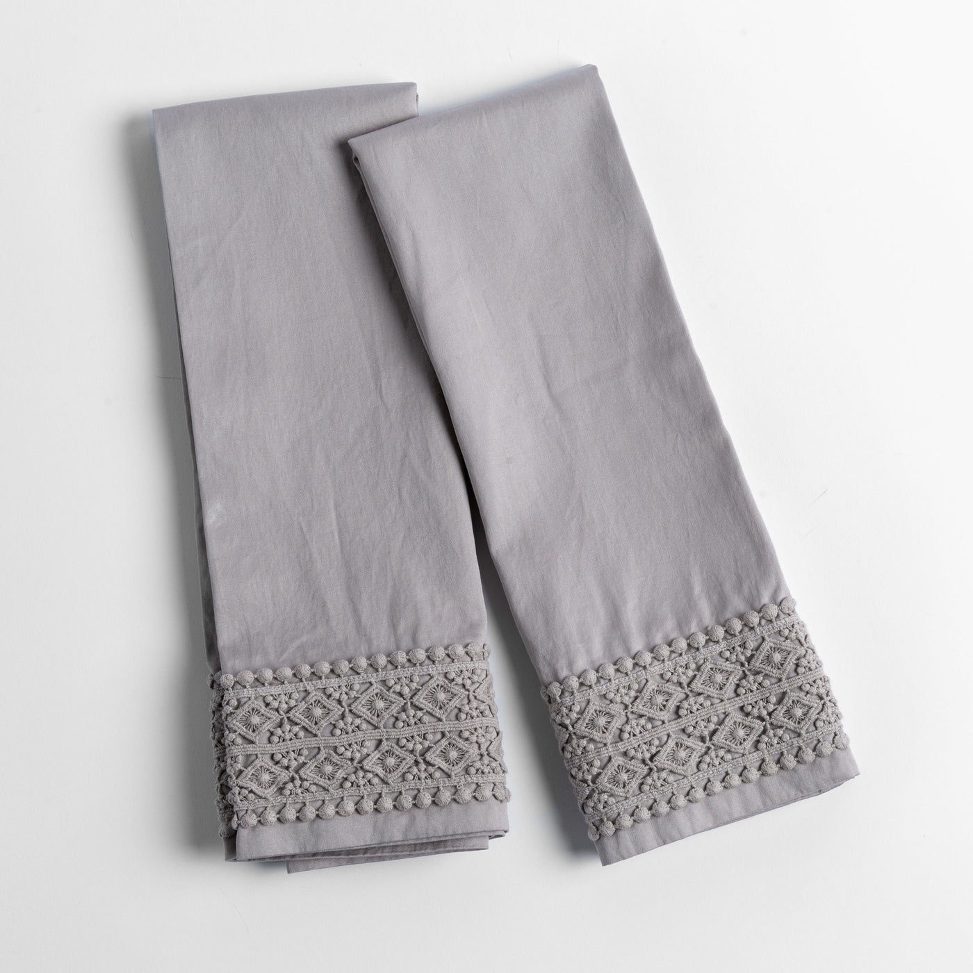 Fog Bria pillowcases folded flat, showing tonal lace crochet trim detail at hem.