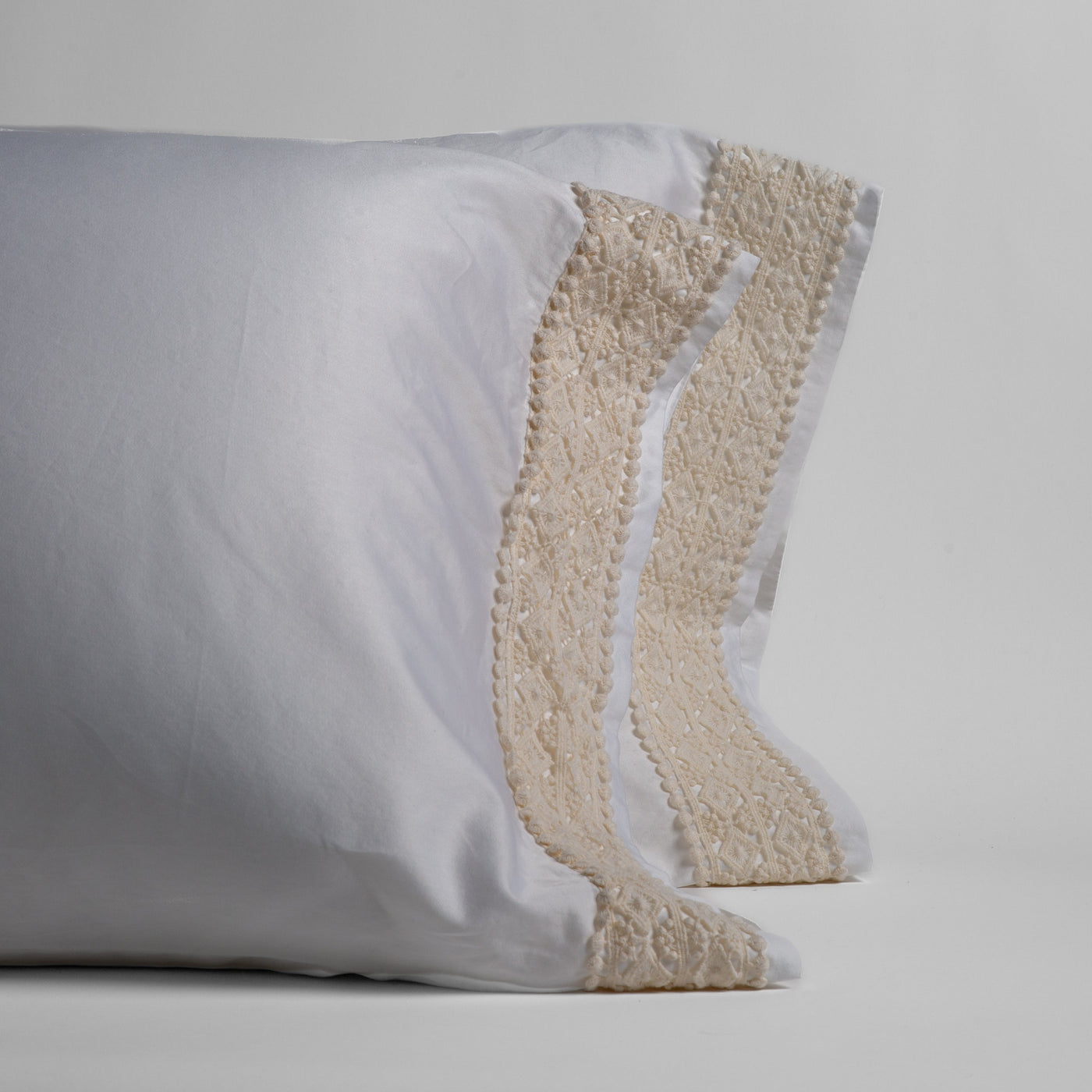 Close-up of Bella Notte Bria pillowcase edges in White with floral lace trim detail.