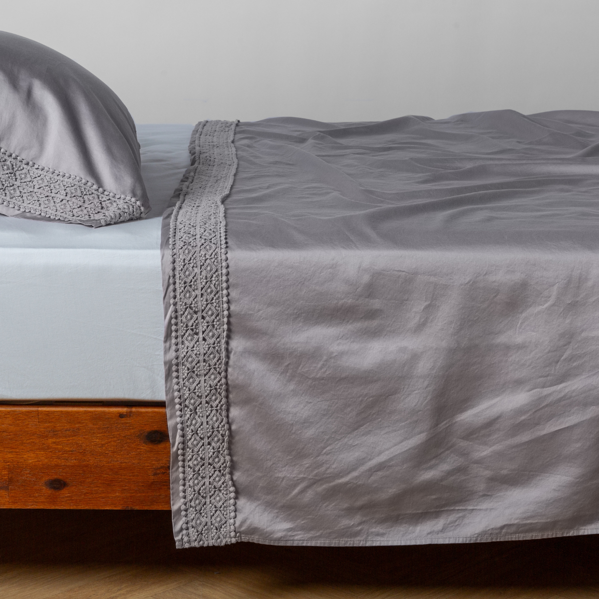 French Lavender flat sheet draped over bed, crochet lace trim detail visible along edge.