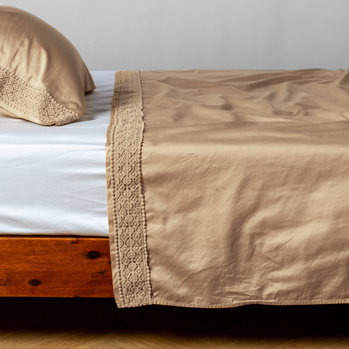 Honeycomb flat sheet folded over bed, showing crochet lace trim detail along edge.