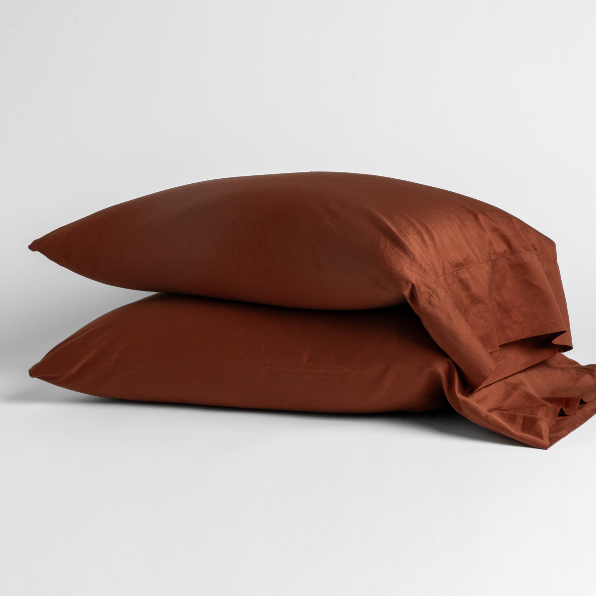 Two Bella Notte Bria pillowcases in Autumn stacked, showing relaxed drape and sheen.