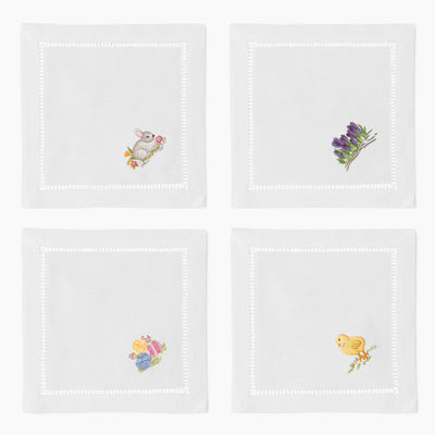 Henry Handwork white linen Easter cocktail napkins with embroidered bunny, crocus, chick, and floral motifs.