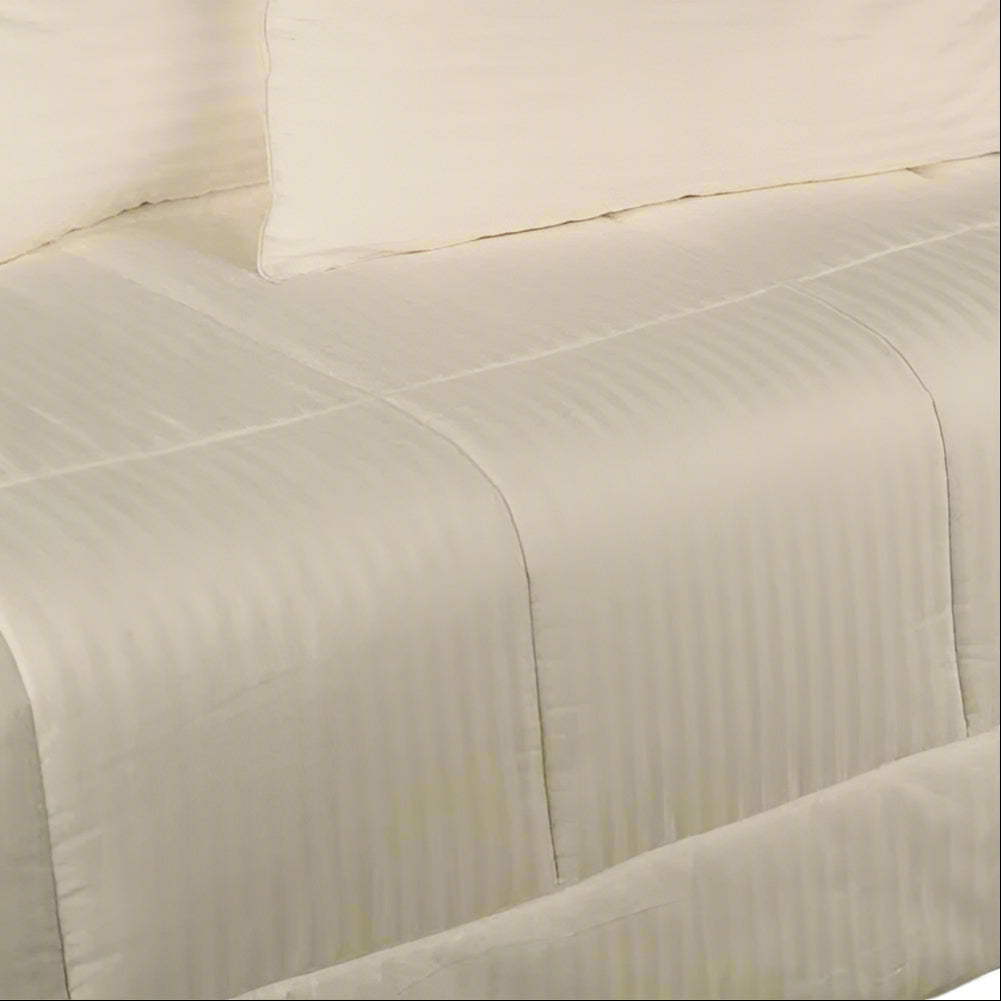 Kumi Kookoon ivory cotton comforter with tonal satin stripes on a made bed.