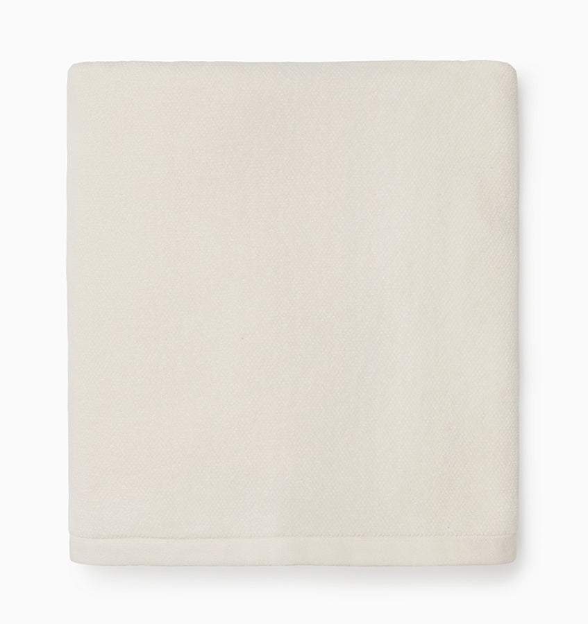 Ivory cotton bath sheet folded flat, showing smooth woven texture.