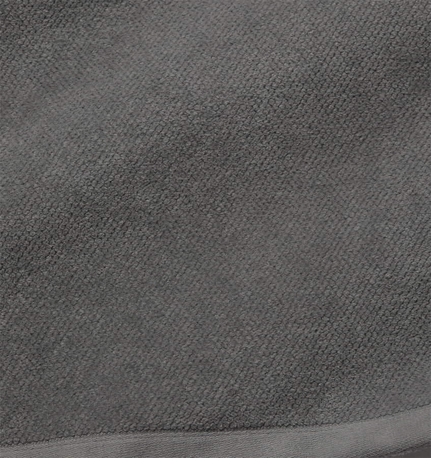 Close-up of slate grey terry loop texture with woven border detail.