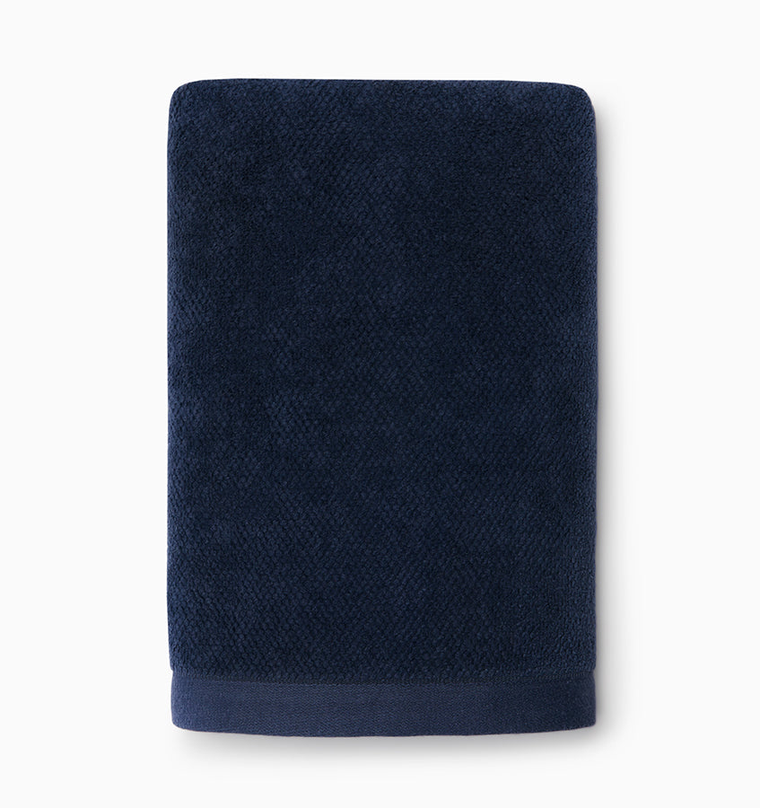Navy terry hand towel with subtle woven texture and smooth border, folded flat.