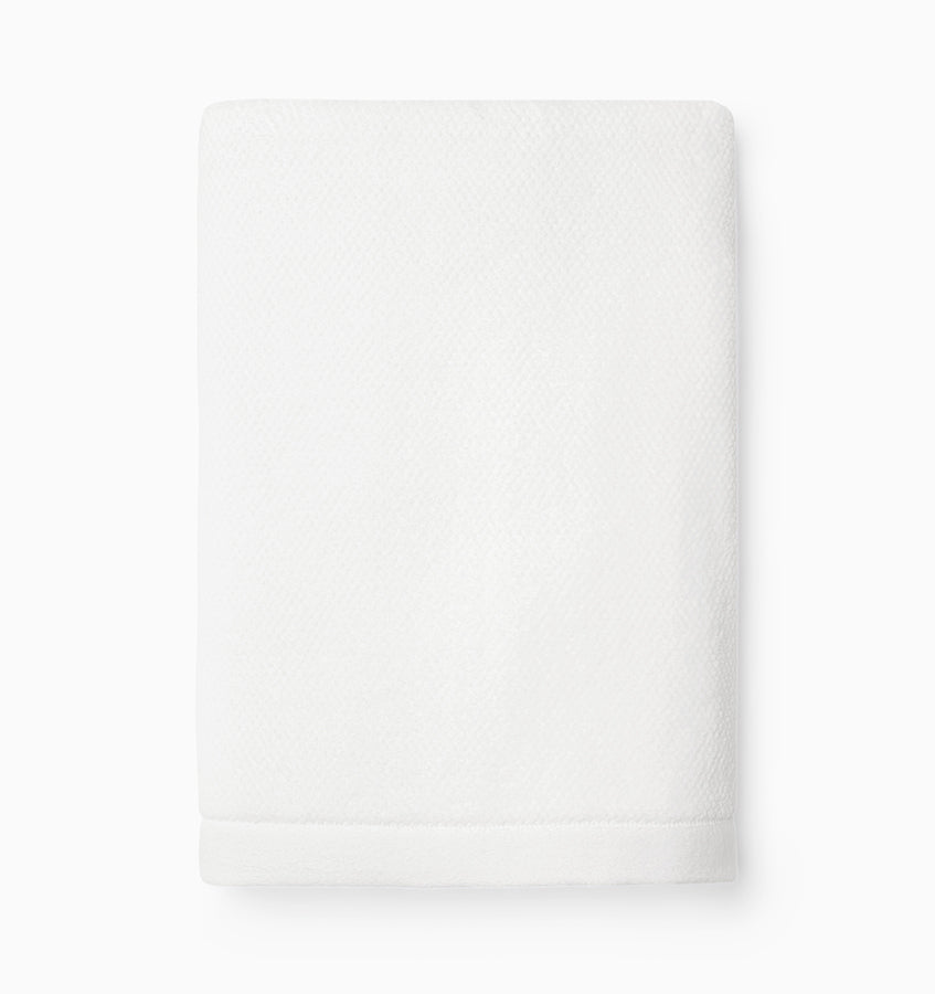 Close-up of folded white Sferra Canedo Nuovo hand towel showing textured cotton weave.
