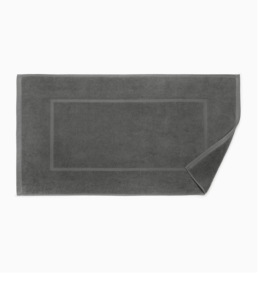 Charcoal terry tub mat with tonal woven border detail, corner folded to show pile texture.