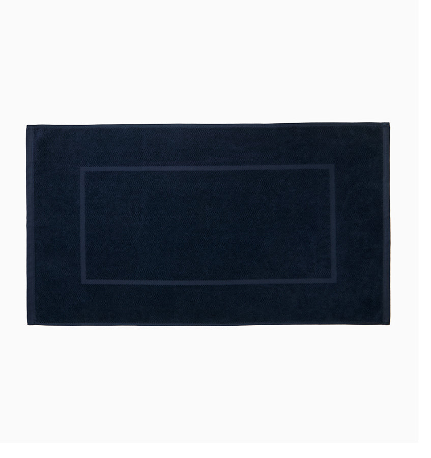 Navy cotton tub mat with tonal woven border rectangle, flat lay.