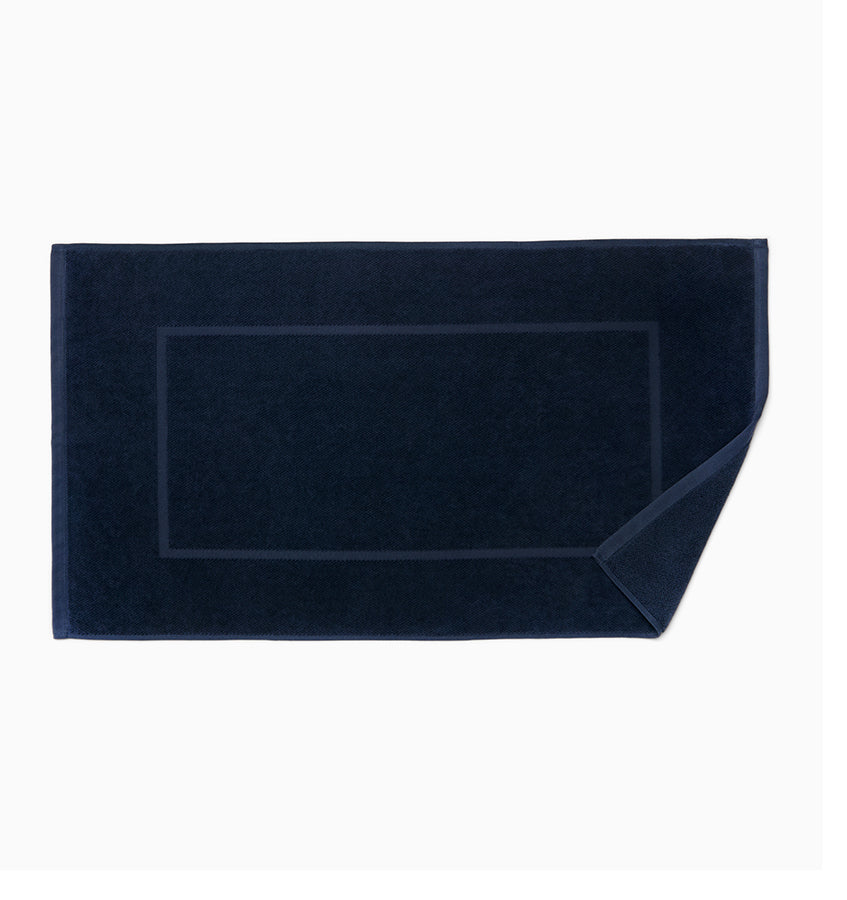 Corner fold detail on navy Sferra Canedo Nuovo tub mat showing terry texture.