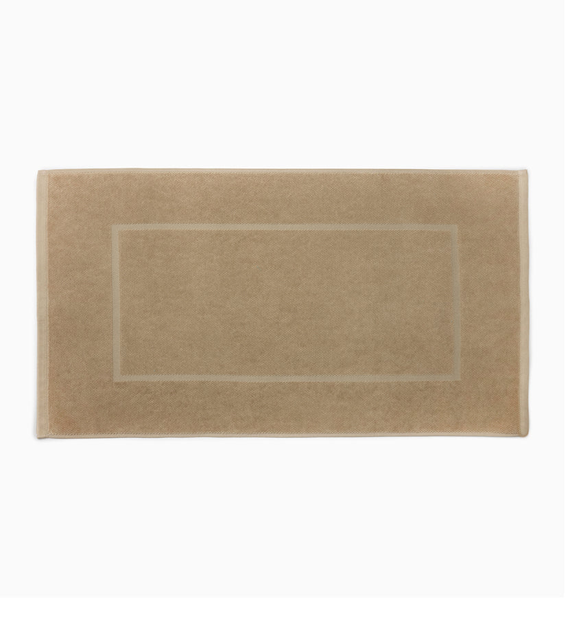 Sferra Canedo Nuovo tub mat in sand with a woven border detail, flat lay.