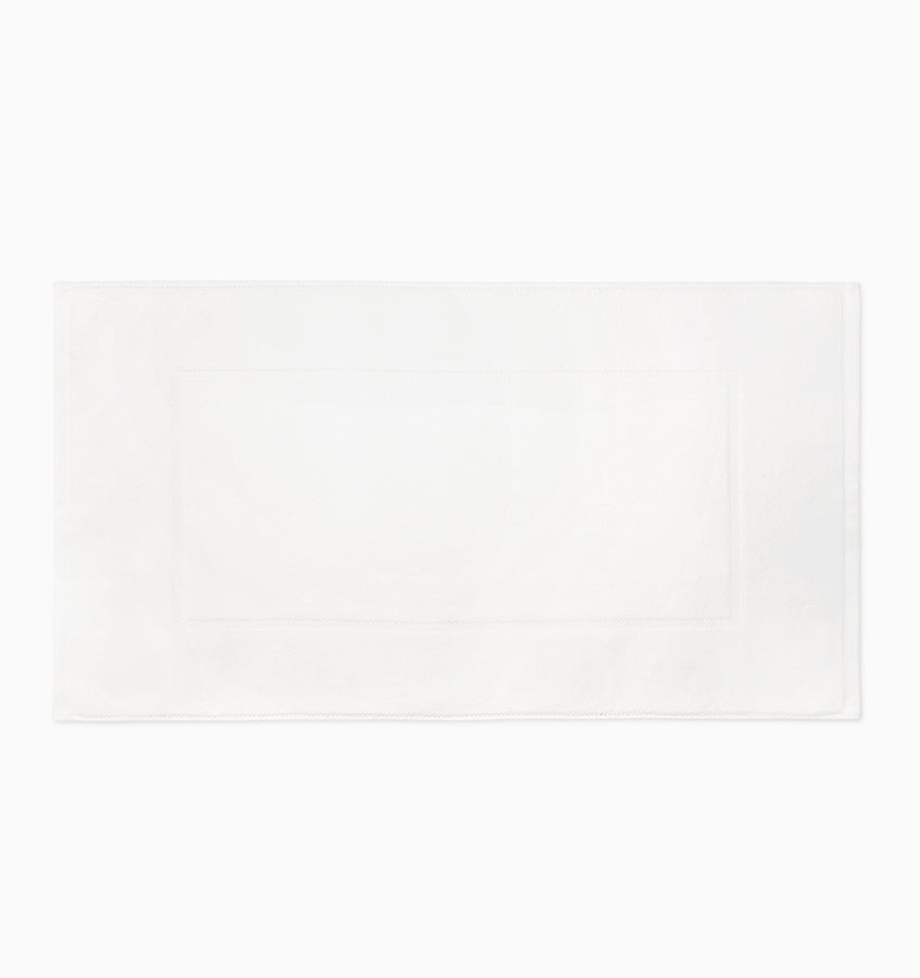 White cotton tub mat with subtle woven border detail, laid flat on white background.