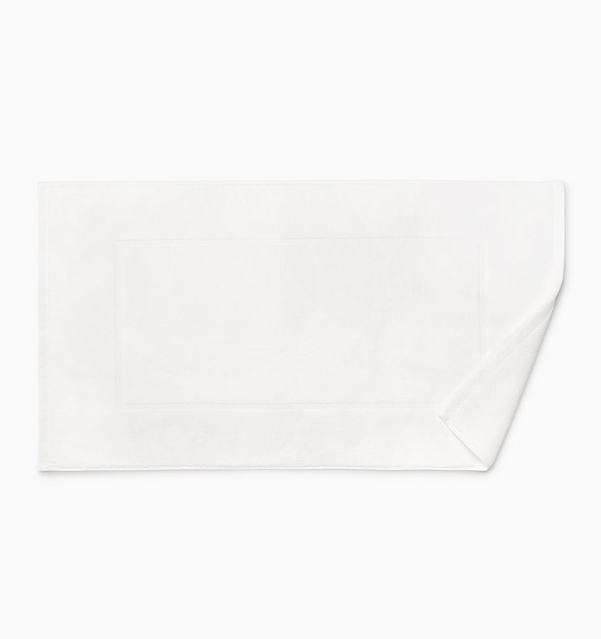 Close-up of Sferra Canedo Nuovo tub mat in white with bordered terry detail.