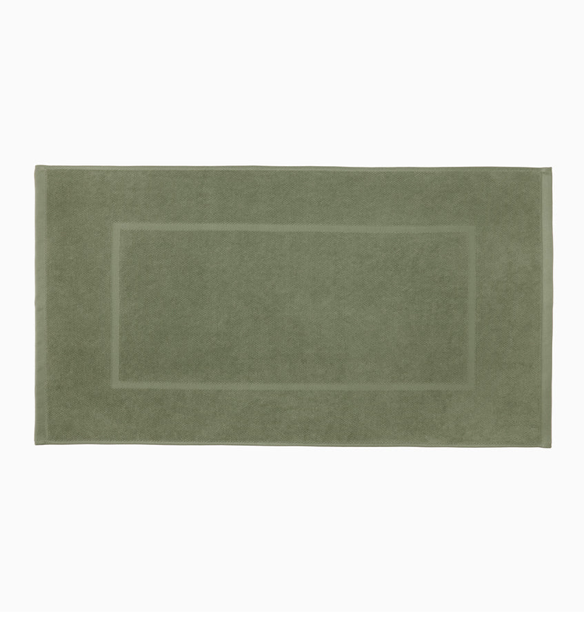 Sage green terry tub mat with tonal woven border detail, flat lay view.
