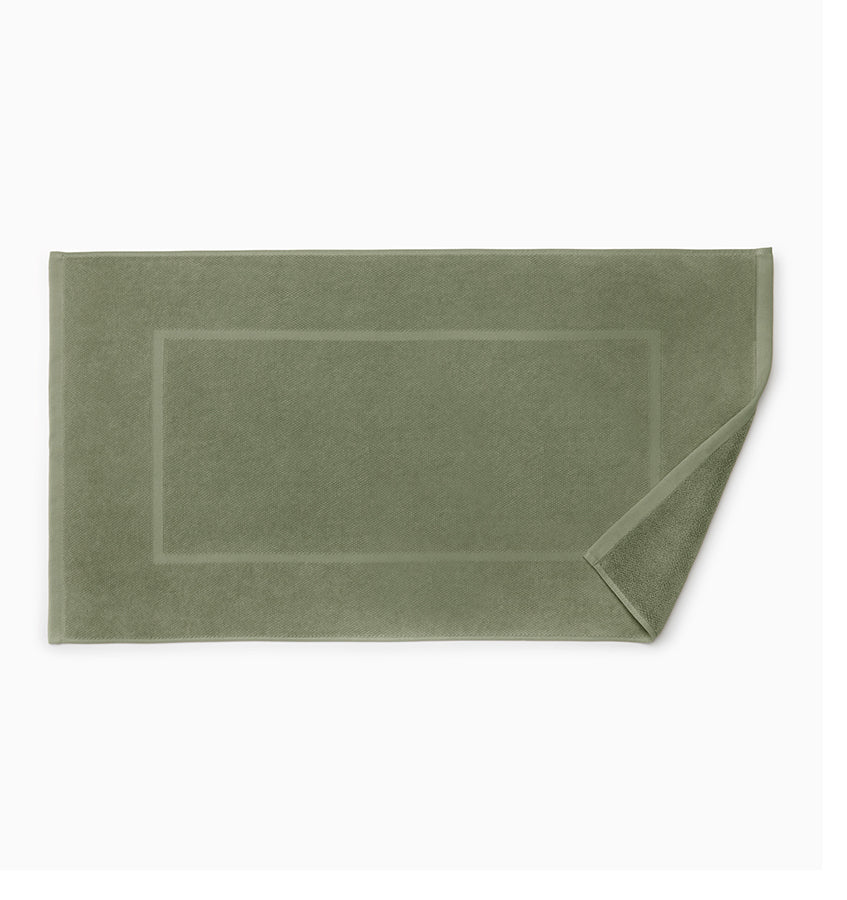 Sage green terry tub mat with woven border detail, corner folded back.