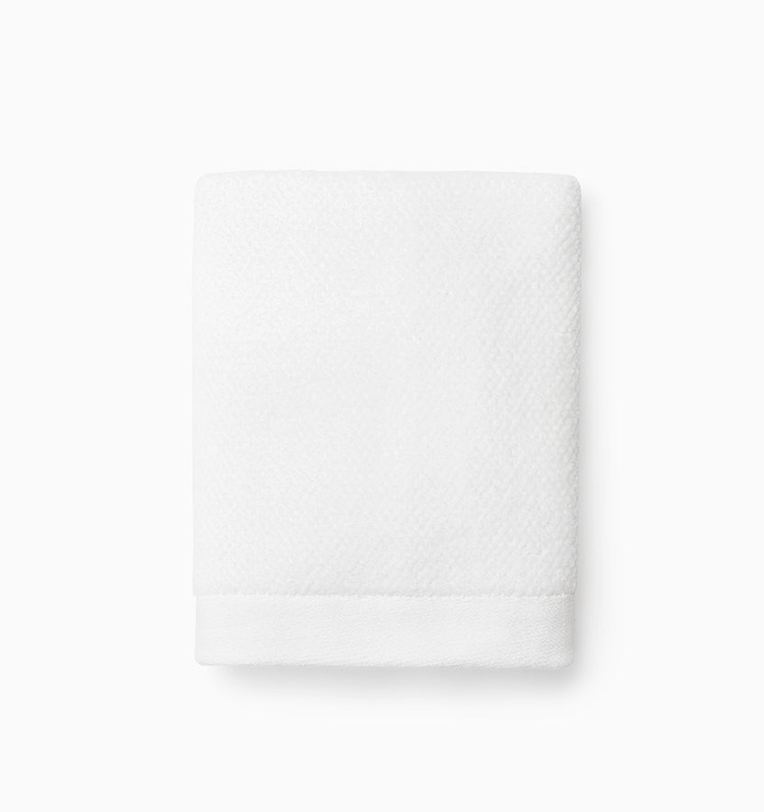 Close-up of folded white Sferra Canedo Nuovo washcloth showing textured weave detail.