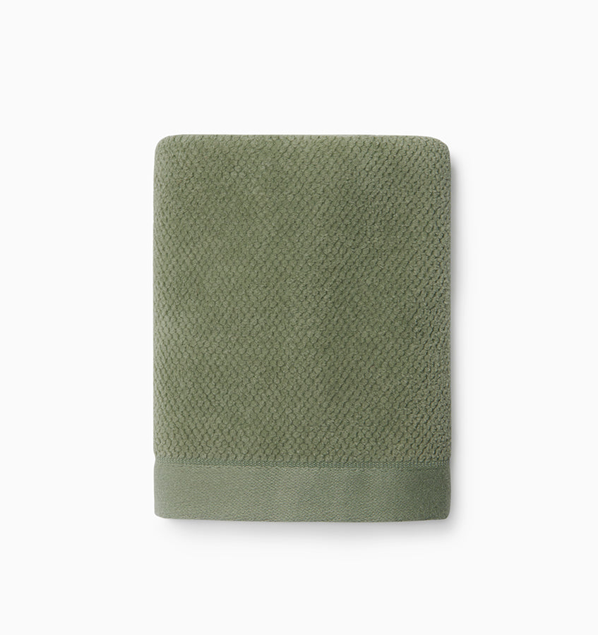 Close-up of Sferra Canedo Nuovo washcloth folded flat in sage green with textured weave.