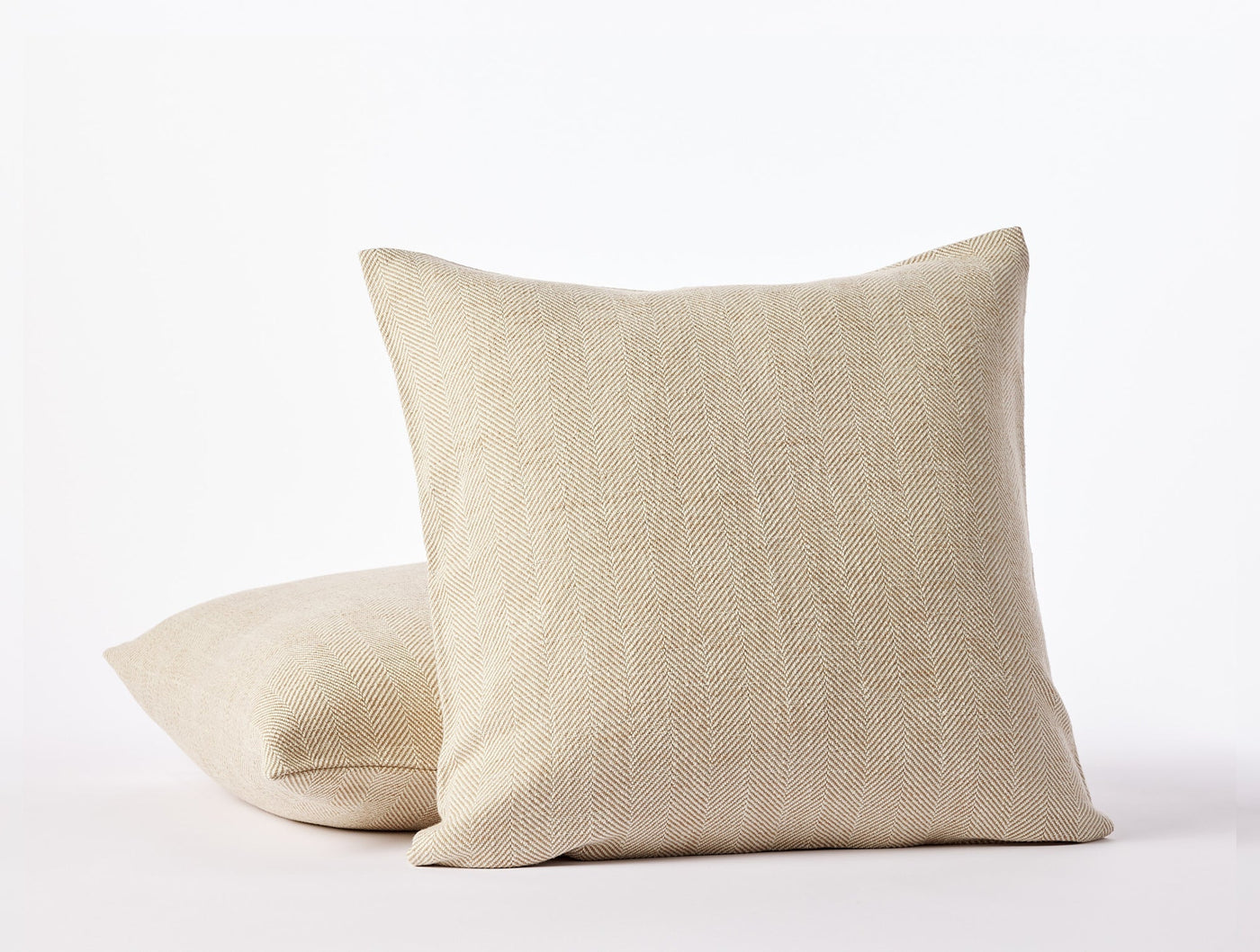 Two Coyuchi Canyon linen pillow covers stacked, natural oat tone, visible open weave texture.