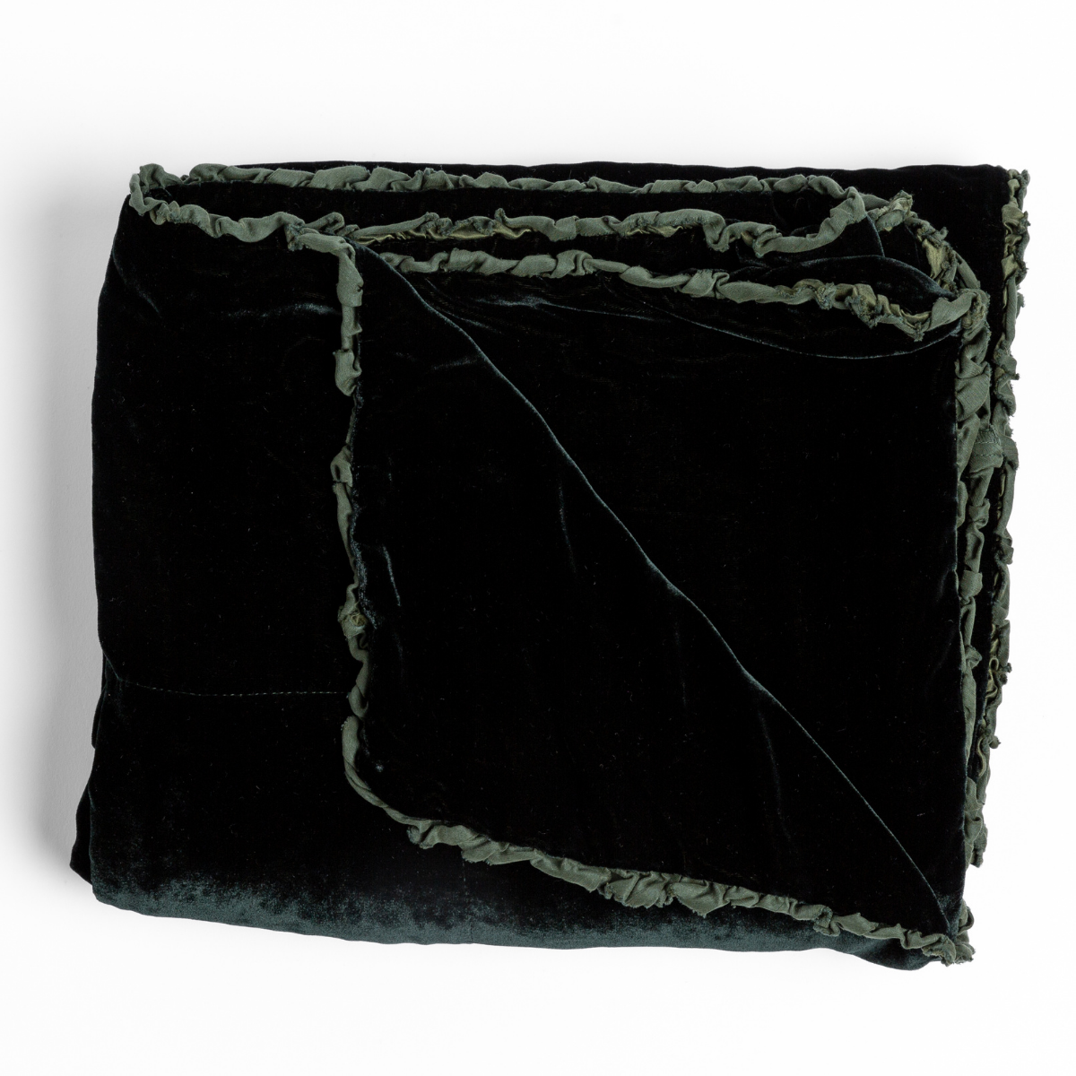 Folded Juniper velvet throw with ruffled trim detail visible at corner edge.