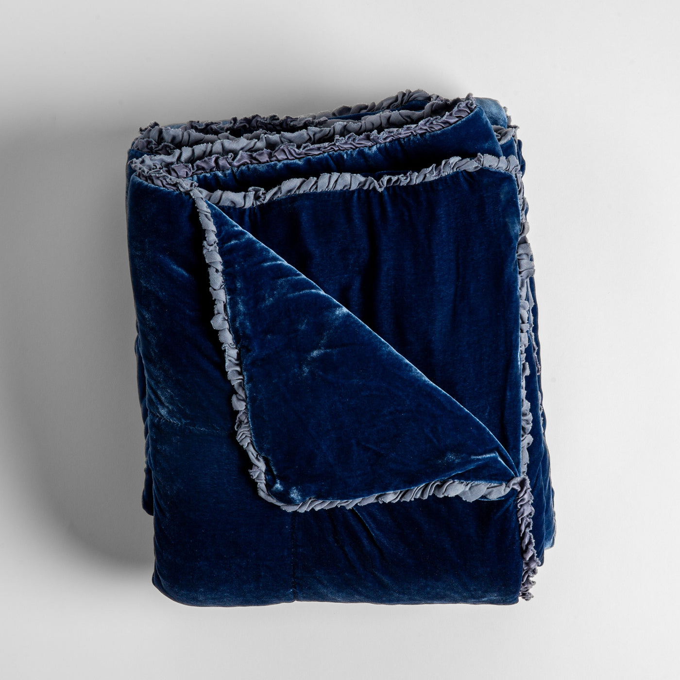 Folded Tahoe Blue velvet blanket showing ruffled trim detail and corner fold.