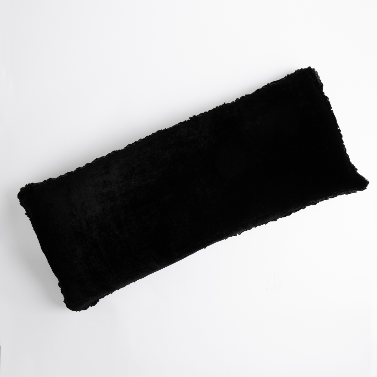 Elongated Corvino Carmen throw pillow with plush faux fur texture, shown flat on white surface.